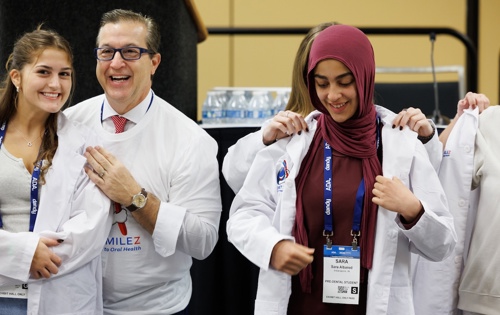 Photo of high schoolers receiving white coats from ADA president and other leaders