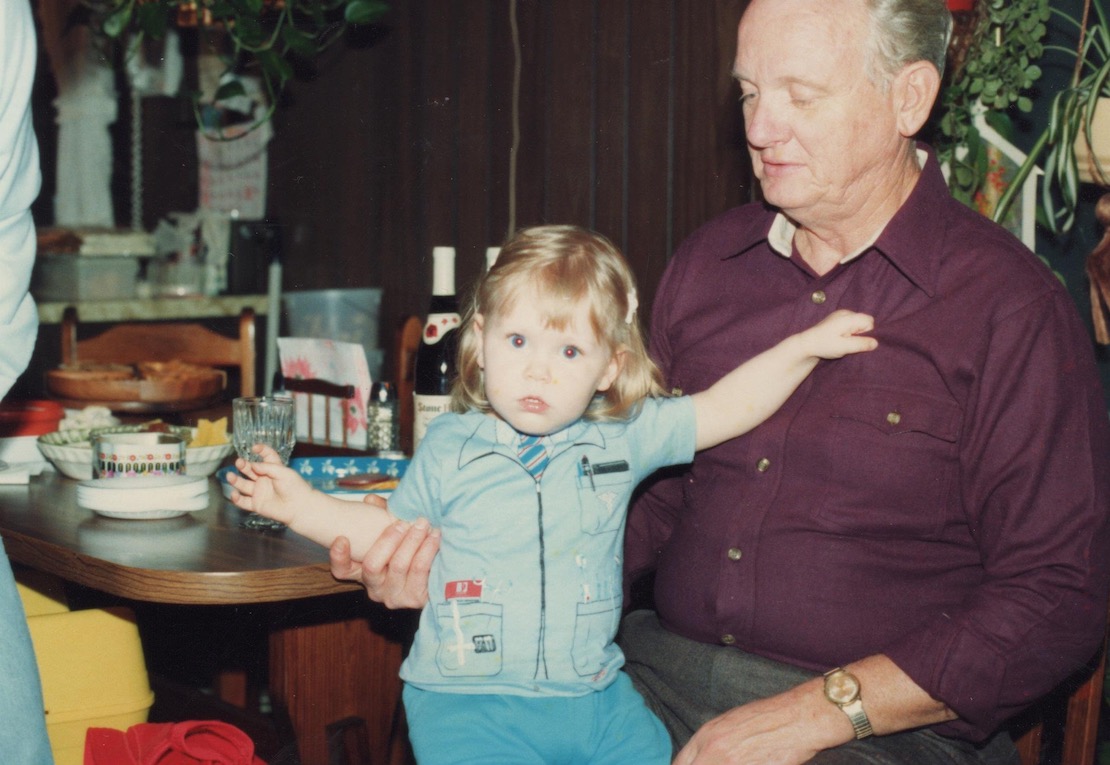Emily Mattingly, D.D.S., wears a dentist costume as a toddler while sitting on the lap of her grandfather W. Chad McCoy, D.D.S.
